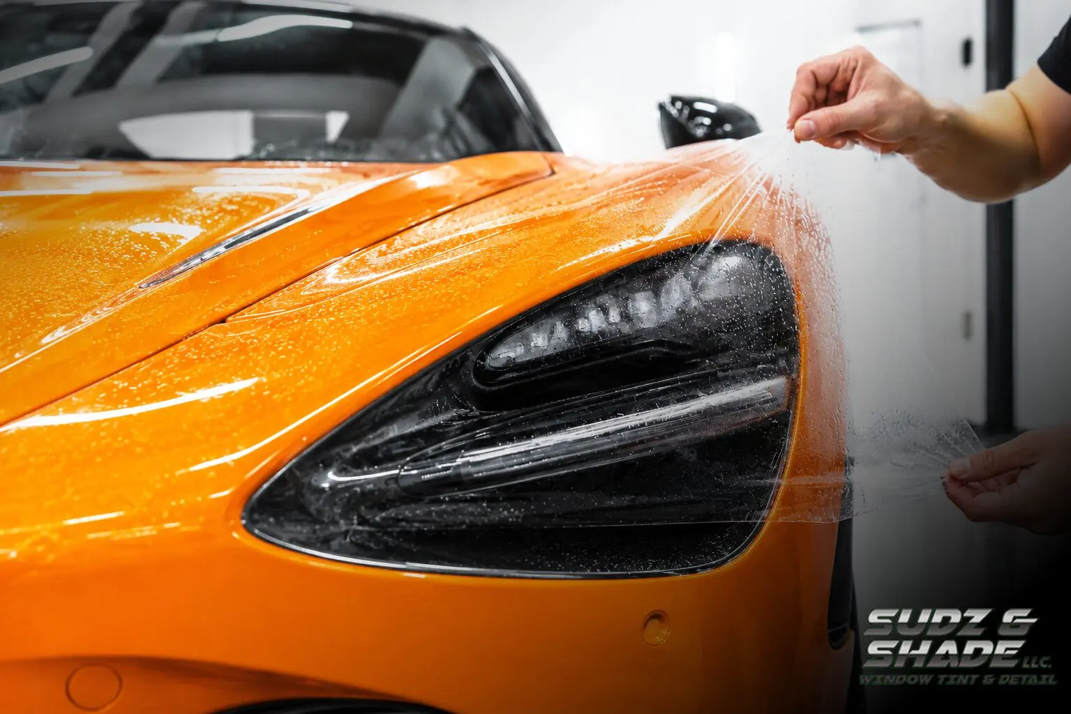 Paint protection film being installed on an orange McLaren in Scottsdale, Arizona
