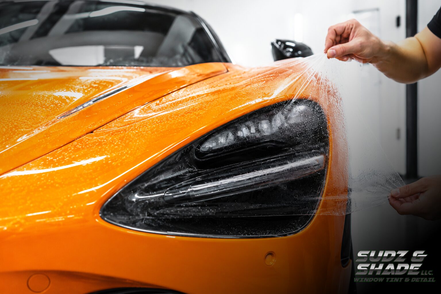 Paint protection film being installed on an orange McLaren in Scottsdale, Arizona